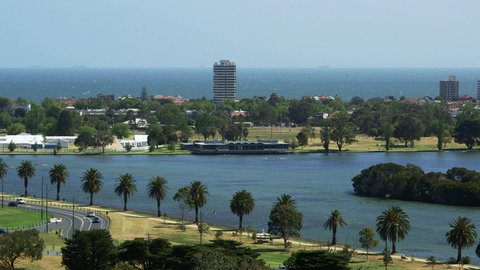 Häuser und Palmen am Meeresufer.