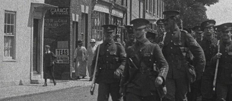 schwarz weiß Bild von Soldaten, die durch einen Ort laufen (Foto: SWR – Screenshot aus der Sendung)