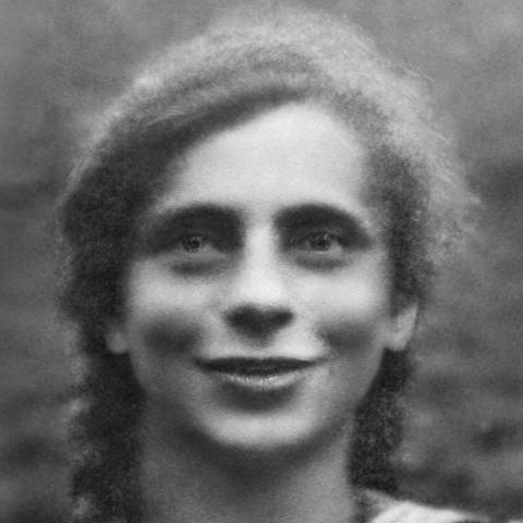 Eine schwarz-weiß Fotografie einer lächelnden jungen Frau