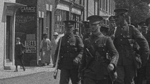 schwarz weiß Bild von Soldaten, die durch einen Ort laufen