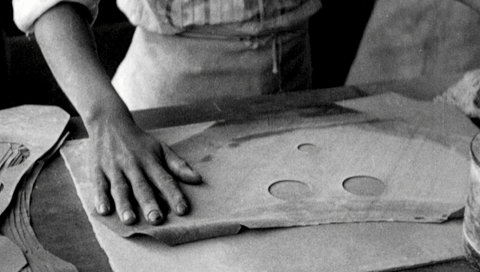 Frau in Fabrik stellt Gasmaske her