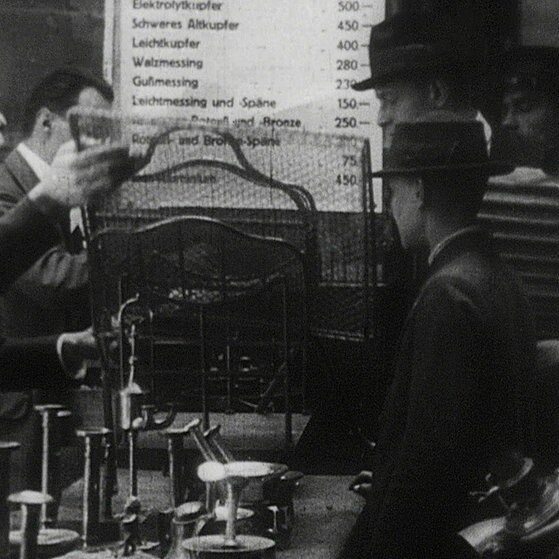 Leute geben Kerzenleuchter u. andere Metallwaren ab