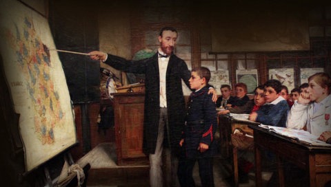 französischer Lehrer vor Schulklasse zeigt auf Frankreichkarte