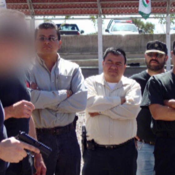 Mann links hat eine Waffe in der Hand, fünf Personen schauen ihm zu. (Foto: SWR – Screenshot aus der Sendung)