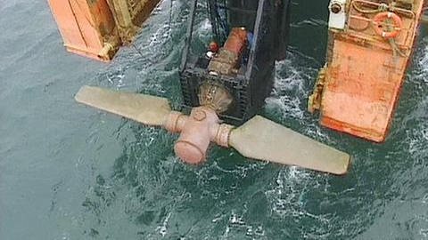 Eine an einer Vorrichtung befestigte, große Schraube hängt über dem Wasser. (Foto: Seaflow inc.)