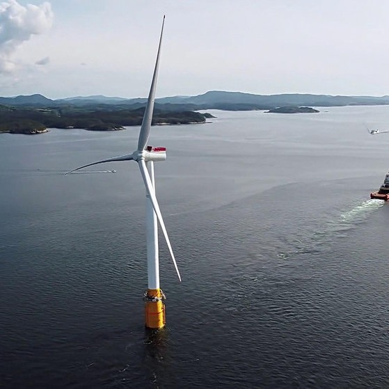 Schiff hat Windkraftanlage im Schlepptau.