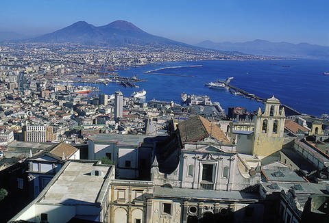 Im Vordergrund die italienische Großstadt Neapel, die im Hintergrund vom Vulkan Vesuv überragt wird. (Foto: Mauritius)