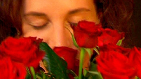 Frau die an Rosen riecht