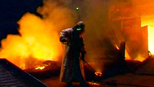 Stahlarbeiter in Schutzkleidung; im Hintergrund glühendes Eisen. (Foto: SWR – Screenshot aus der Sendung)