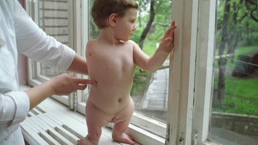 Kind mit verkrüppelten Beinen und nur einem Arm.