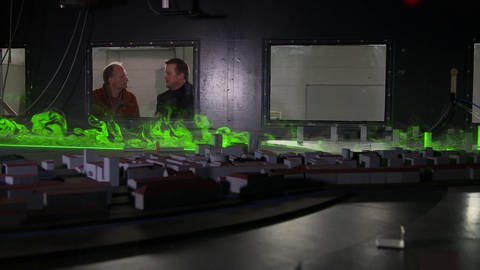 Modell einer Stadt mit grün dargestellten Windverwirbelungen.