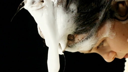 Eine Frau wäscht sich die Haare.