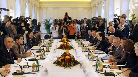 Teilnehmer der 1. Deutschen Islam Konferenz sitzen in der Orangerie des Schlosses Charlottenburg in Berlin am Konferenztisch