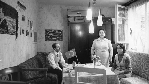 Schwarzweiß-Foto: Eine türkische Gastarbeiterfamilie in den 1970er-Jahren in ihrer Wohnung in Köln