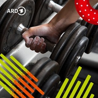 Eine Hand greift zu einer Hantel im Fitnessstudio.