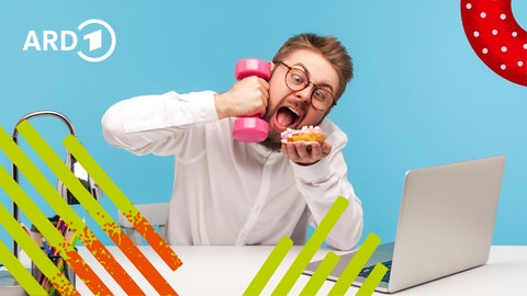 Ein Mann sitzt vor seinem Laptop verschlingt einen Donut und hält eine Hantel in der Hand.