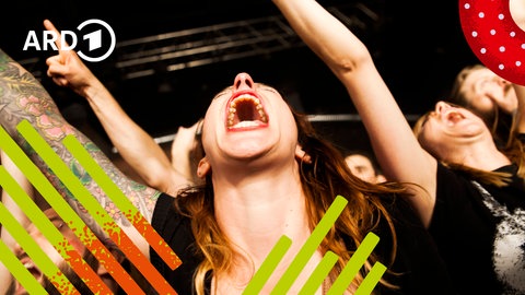 Junge Menschen freuen sich bei einem Konzert und tanzen