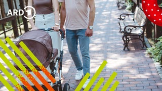 Eltern gehen spazieren und schieben einen Kinderwagen vor sich.