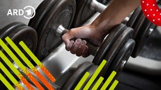 Eine Hand greift zu einer Hantel im Fitnessstudio.