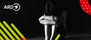 Ein trauernder Mensch sitzt kauernd auf dem Boden und wirkt verzweifelt.