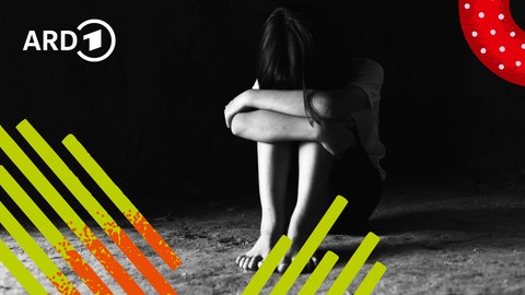 Ein trauernder Mensch sitzt kauernd auf dem Boden und wirkt verzweifelt.