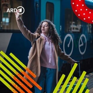 Eine junge Frau steht mit einem Koffer am Bahnhof vor einem Zug und winkt zum Abschied in die Ferne.