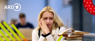 Eine junge Frau sitzt mit ängstlichem Blick am Schreibtisch mit Büchern neben sich.
