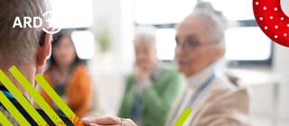 Eine Frau legt zuversichtlich ihre Hand auf die Schulter eines Mannes. 