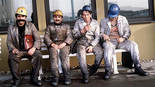 Türkische Bergarbeiter sitzen auf einer Bank
