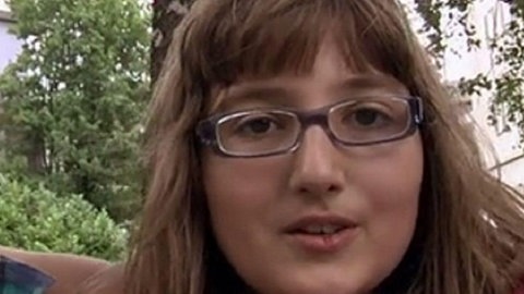 Drei Kinder halten sich in den Armen.