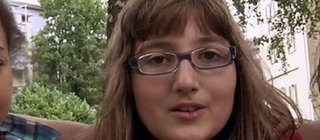 Drei Kinder halten sich in den Armen.