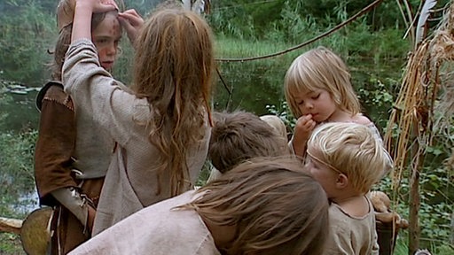 Die Kinder bemalen sich gegenseitig mit Rötel.