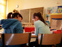 Zwei Mädchen sitzen an einer Schulbank. (Rechte: dpa/Oliver Berg)