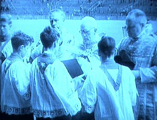 Pfarrer mit Messdienern im Stadion [Klick auf das Bild, schließt das Fenster]