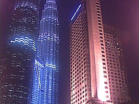 Beleuchtete Hochhäuser bei Nacht [Klick auf das Bild, schließt das Fenster]