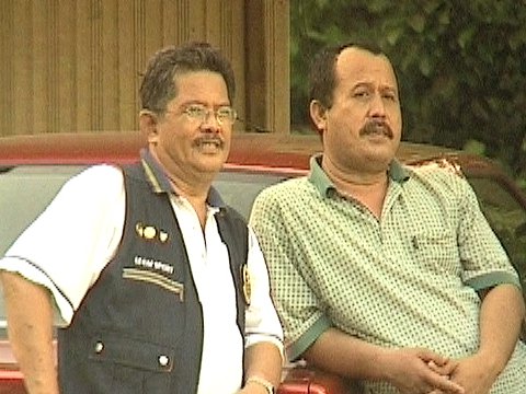 Zwei Männer lehnen an einem Auto [Klick auf das Bild, schließt das Fenster]