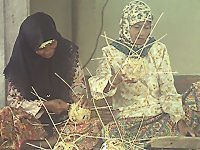 Zwei Frauen bei der Herstellung von Sepak Takraw Bällen aus Rattan