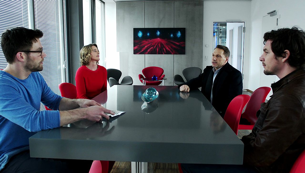 Farbkontrast Bluesky in rot und blau, Kommissare in schwarz und braun 