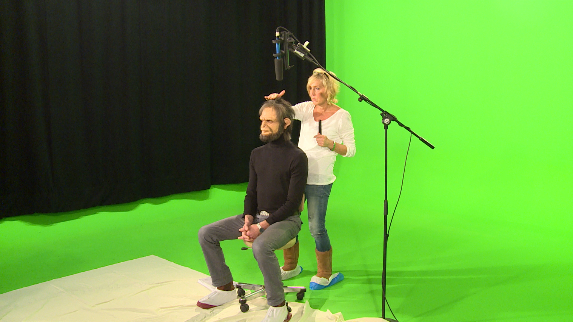 Die Maskenbildnerin nimmt letzte Korrekturen vor