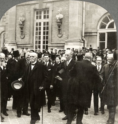 Georges Clemenceau und Woodrow Wilson in einer Gruppe von Politikern vor dem Schloss von Versailles (Foto: imago images / ZUMA Press)