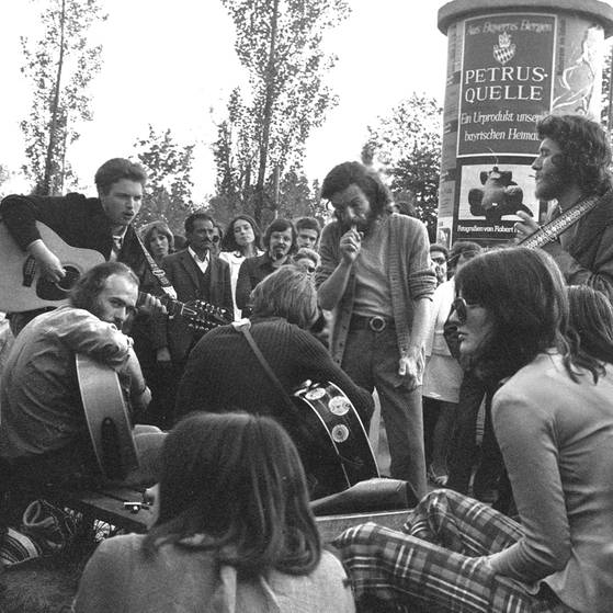 Junge Leute mit Gitarren sitzen vor Litfasssäule (Foto: imago images / Heinz Gebhardt)