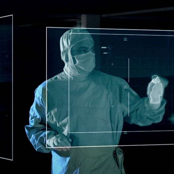 Arzt in OP-Kleidung mit Projektion von Schwangerer und Baby. (Foto: SWR – Screenshot aus der Sendung)