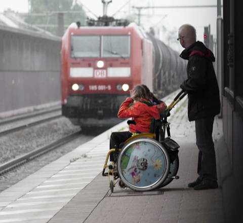Mann mit Kind im Rollstuhl auf Bahnsteig. (Foto: SWR – Screenshot aus der Sendung)