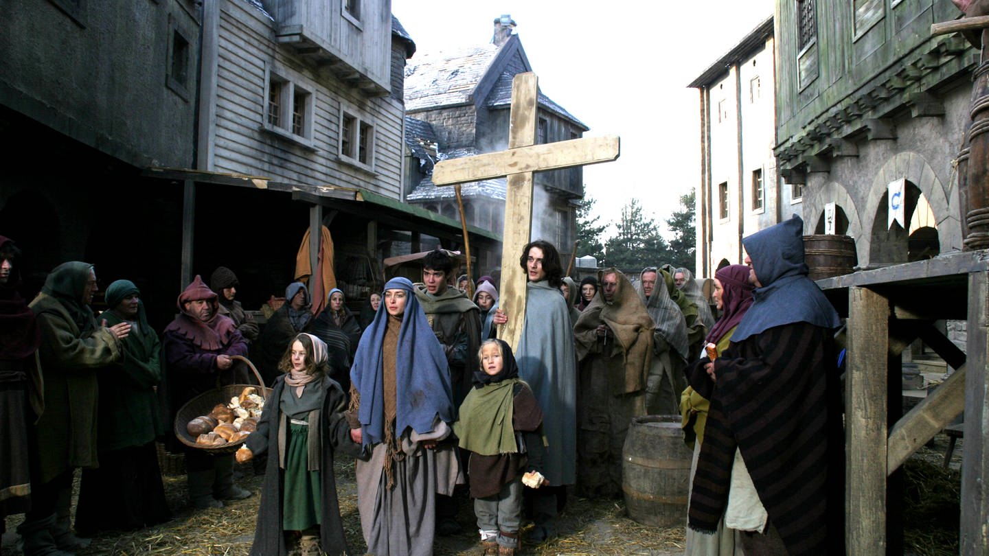 Kinder in mittelalterlicher Kleidung ziehen durch ein Dorf und tragen ein Kreuz. (Foto: WDR/Martin Papirowski)