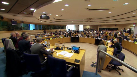 Ein runder, amphitheaterähnlicher Sitzungssaal in dem mehrere Dutzend Politiker zusammensitzen.