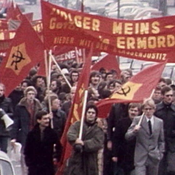 Demonstranten mit roten Transparenten (Foto: SWR - Screenshot aus der Sendung)