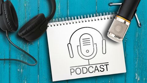 Mikrofon, Kopfhörer und ein Symbol für Podcasts auf einem blauen Tisch