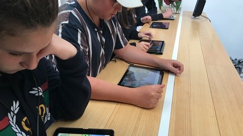 Schüler*innen vor Tablets.
