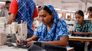 Eine Arbeiterin in Bangladesh an einer Nähmaschine