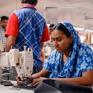 Eine Arbeiterin in Bangladesh an einer Nähmaschine